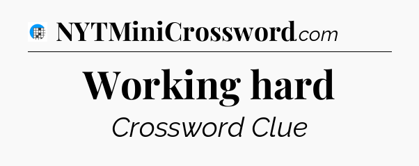 Working hard Crossword Clue