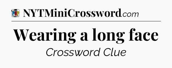 Wearing a long face Crossword Clue