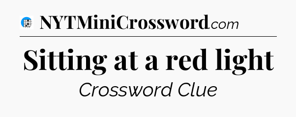 Sitting at a red light Crossword Clue